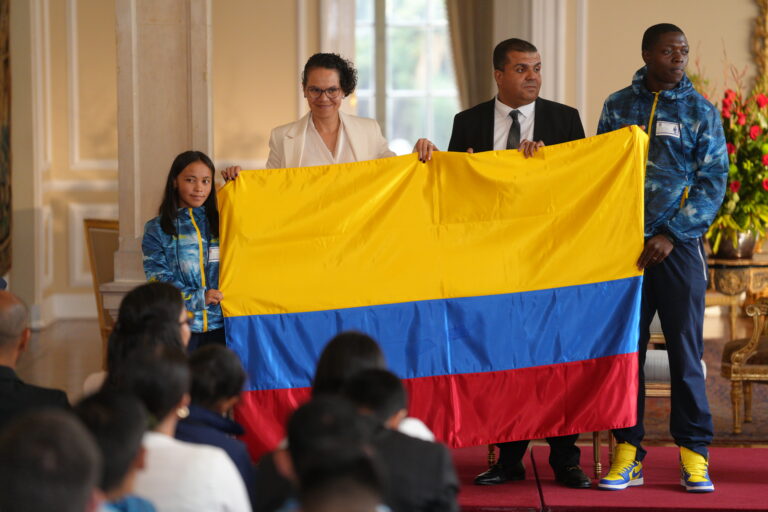 La delegación colombiana recibe la bandera nacional antes de su viaje a Chile